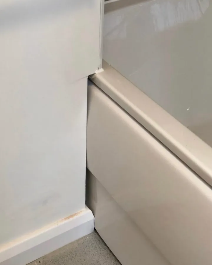 A white bath panel meeting painted boxing and skirting.